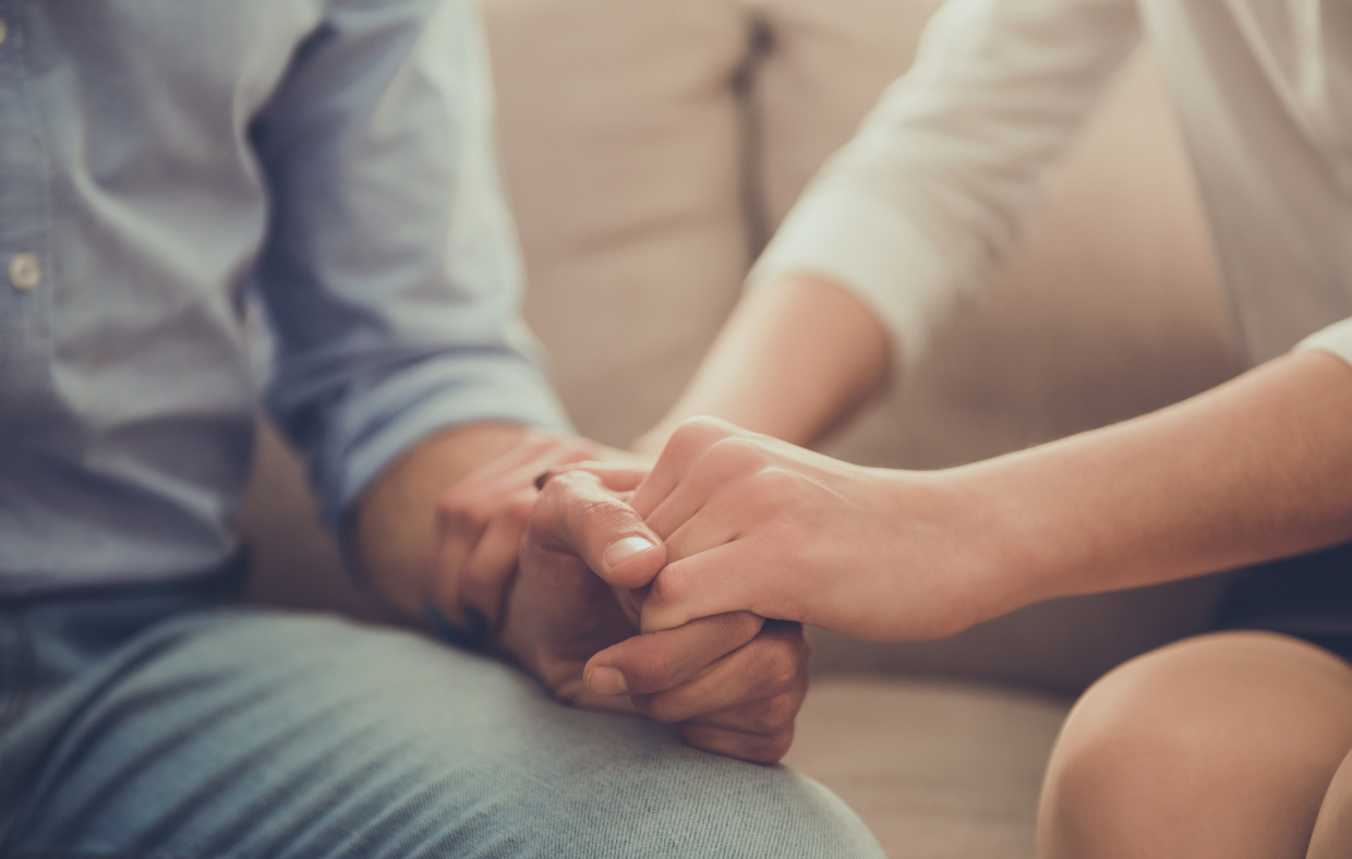 Photo of two people holding hands during talk therapy, a depression treatment.