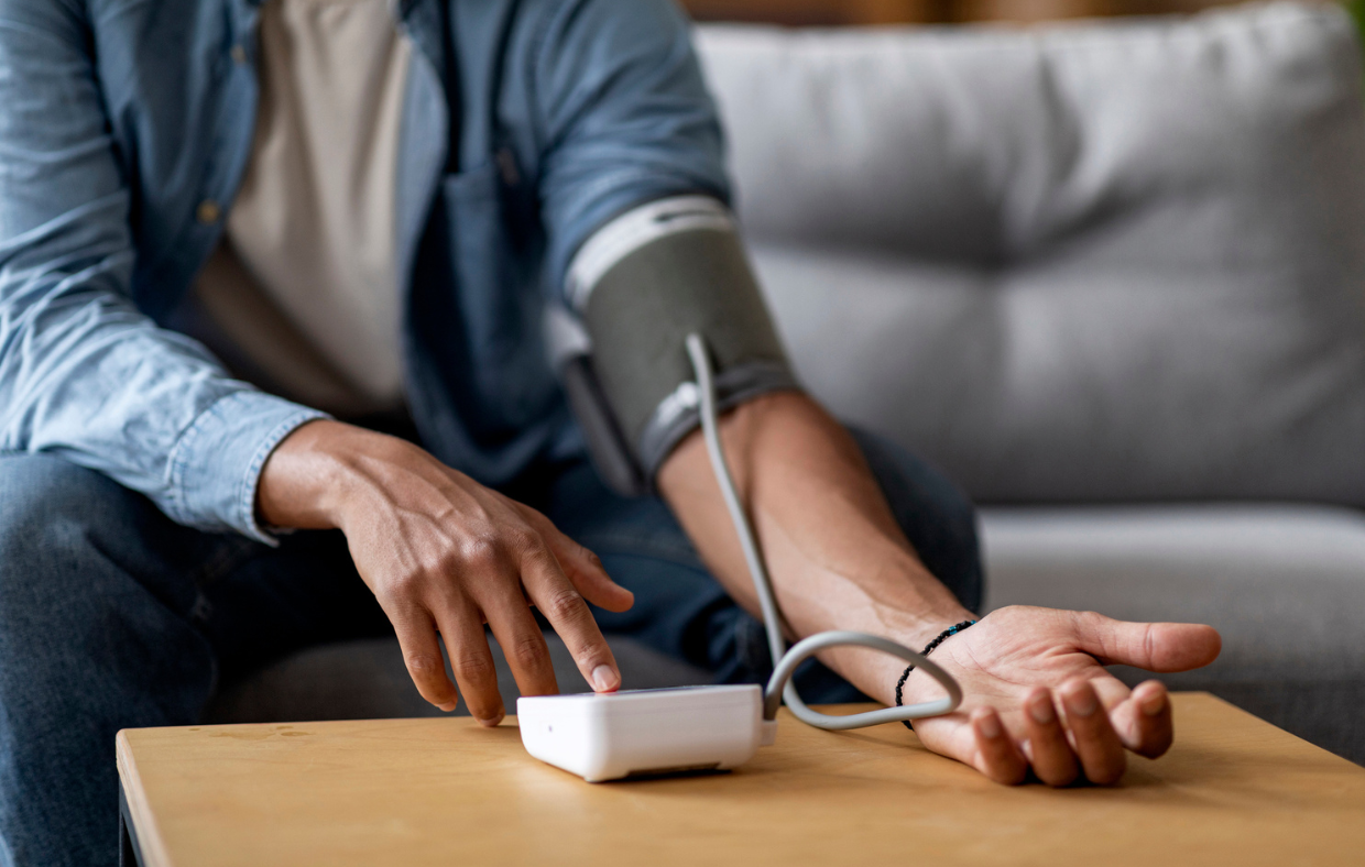 Photo of a person taking their blood pressure to monitor hypertension.