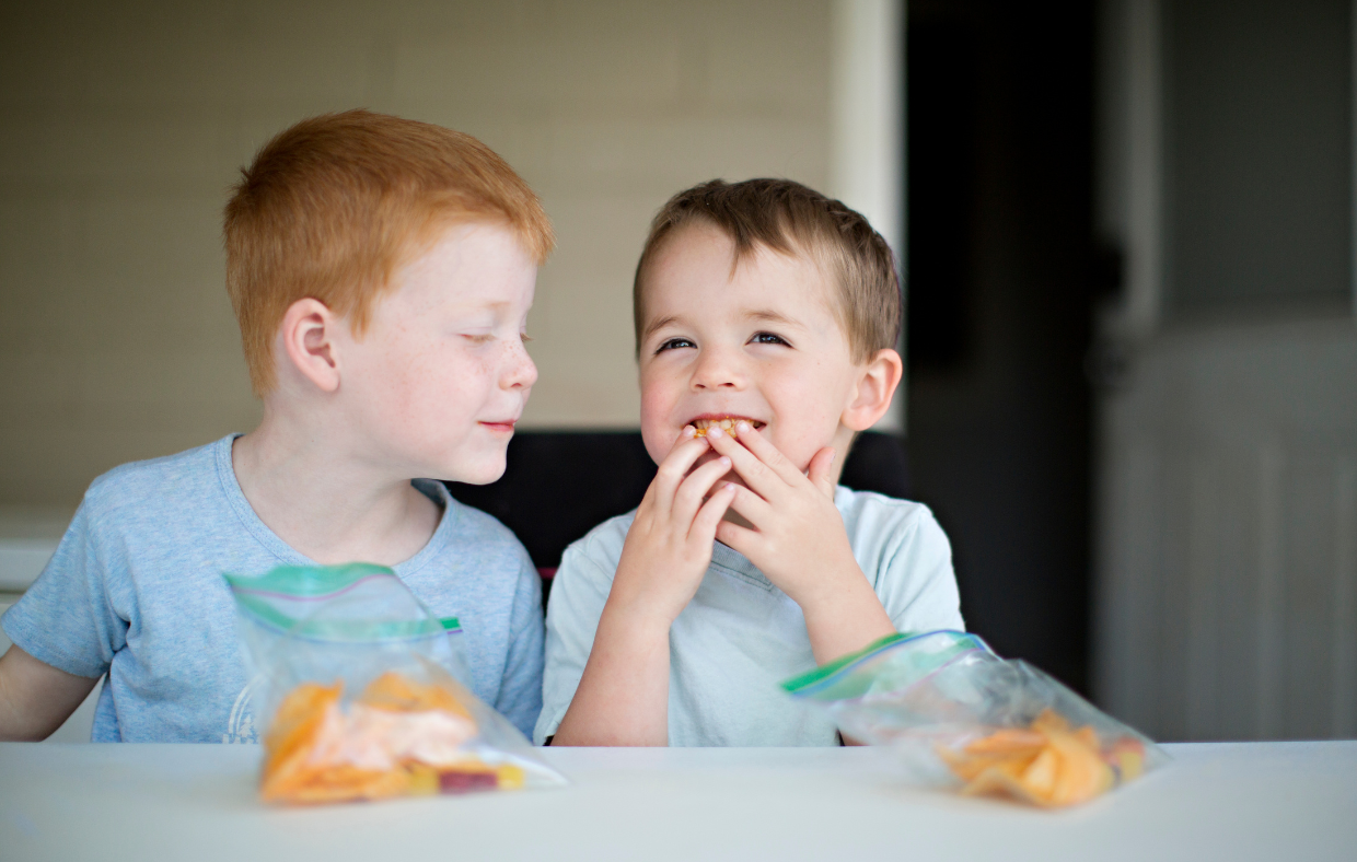 Two children eating food showing importance of health diets for childhood health.